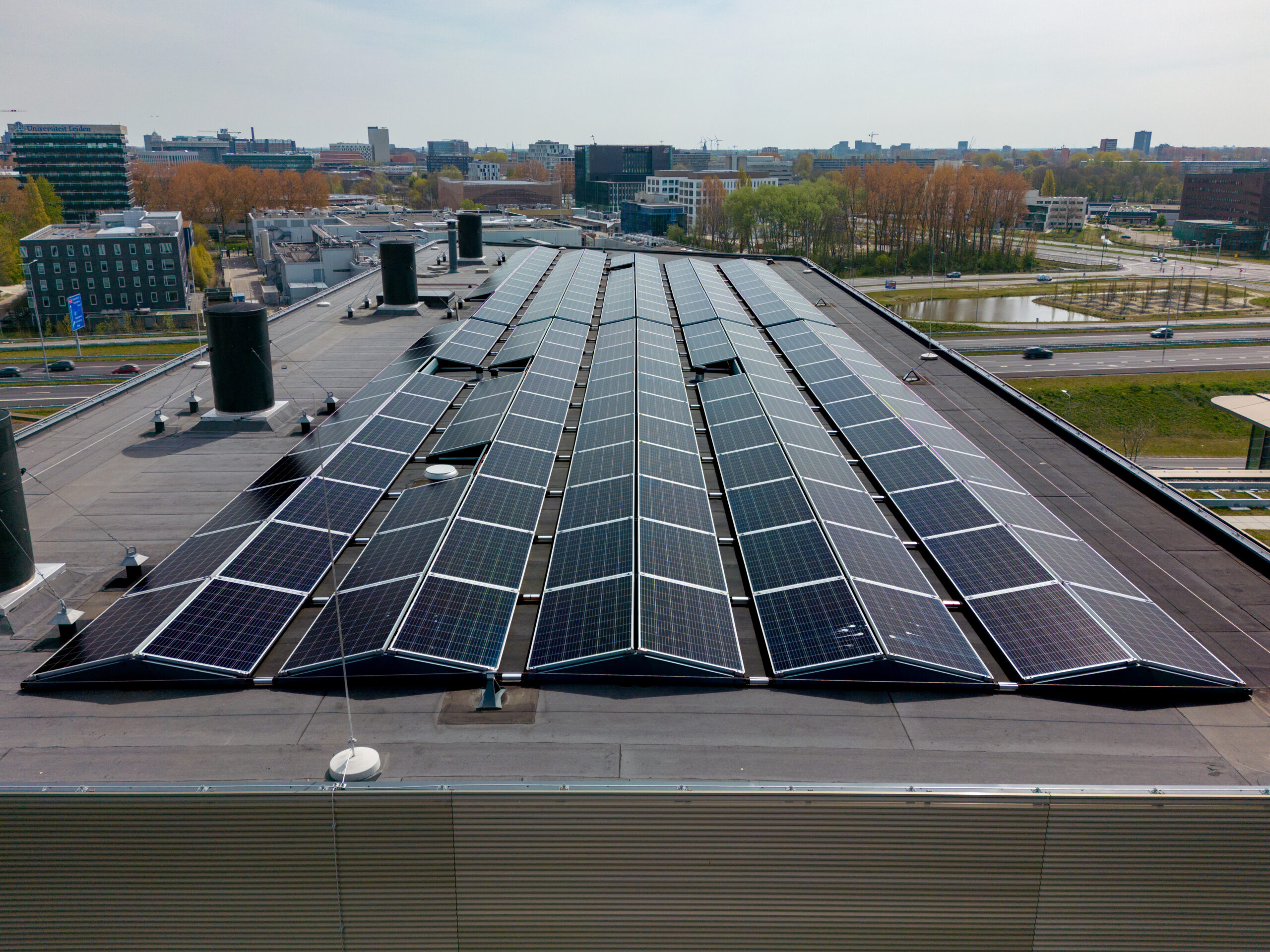 This picture shows many solar panels on the roof of an office building.